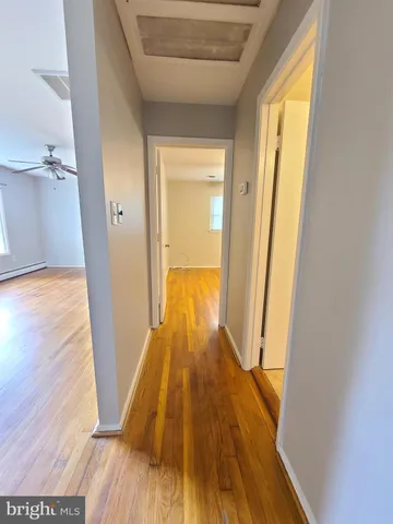 a view of a hallway with wooden floor and staircase