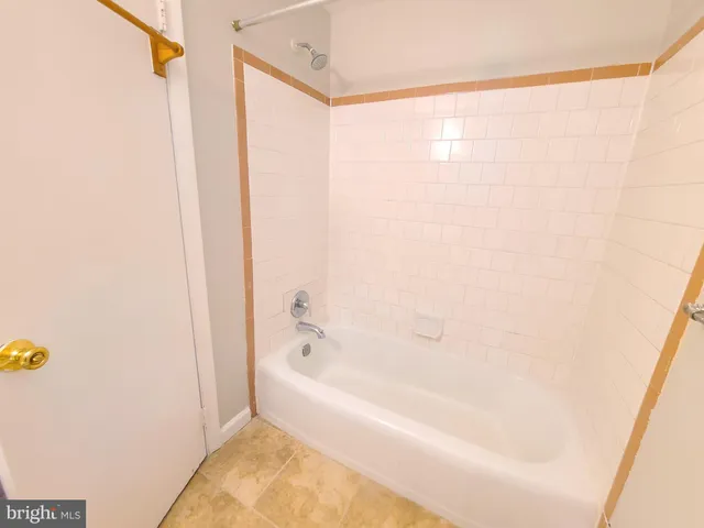 a white bath tub sitting next to a shower