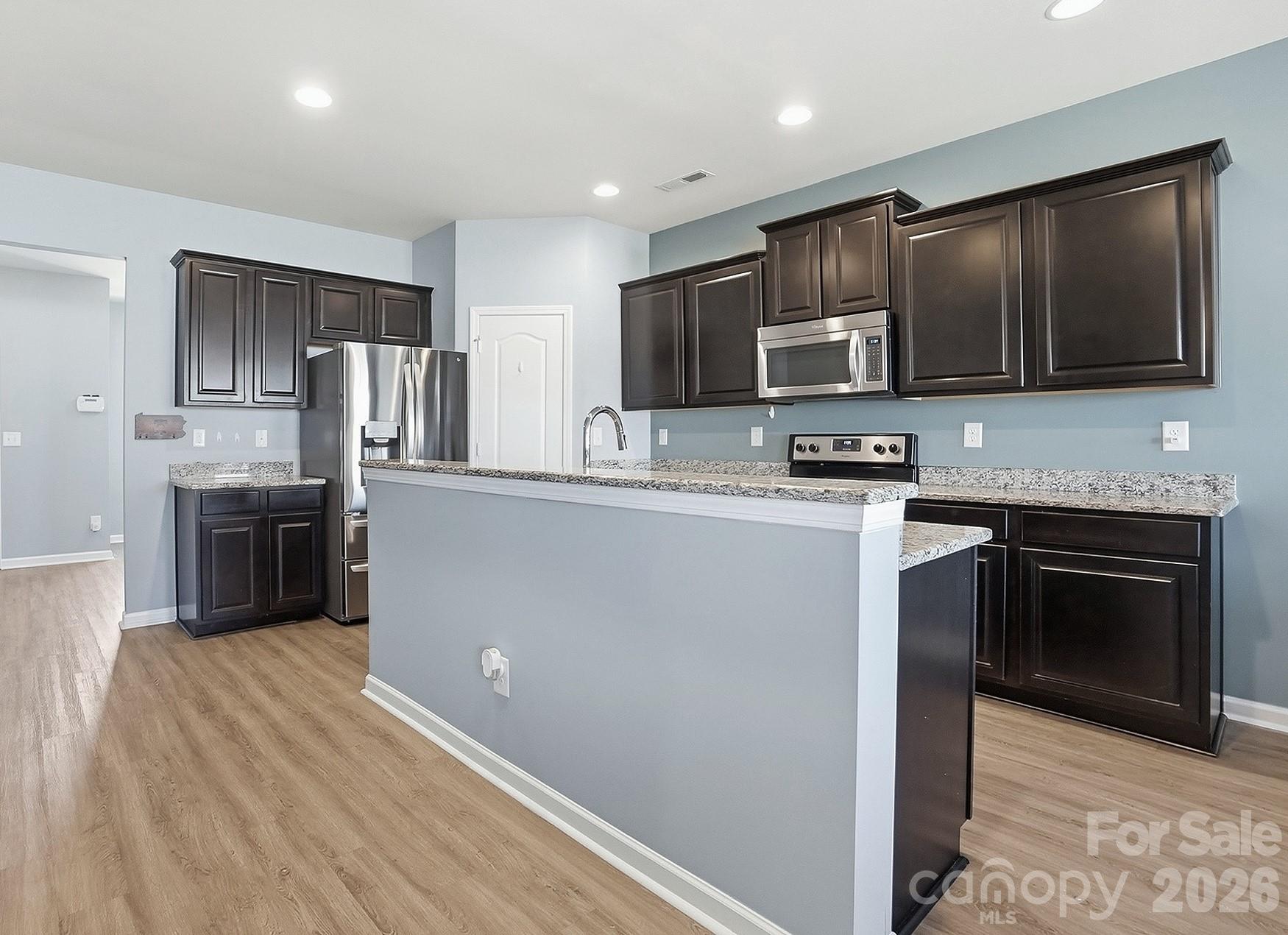 2009 Houndscroft Road Indian Trail, NC 28079 - Photo 4 of 25 a kitchen with stainless steel appliances granite countertop a stove top oven a sink and dishwasher a refrigerator with wooden floor