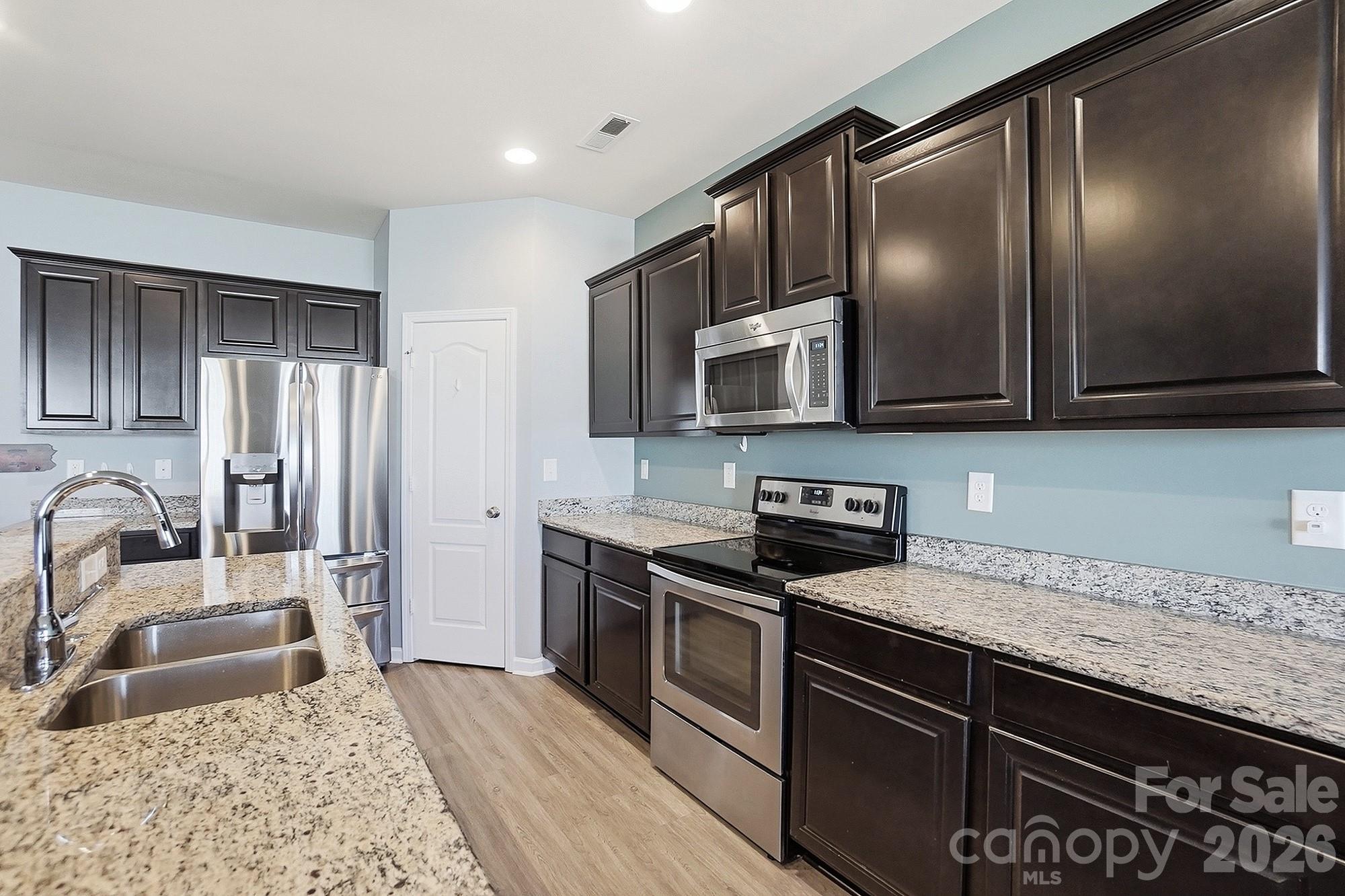 2009 Houndscroft Road Indian Trail, NC 28079 - Photo 5 of 25 a kitchen with stainless steel appliances granite countertop a sink stove microwave and refrigerator