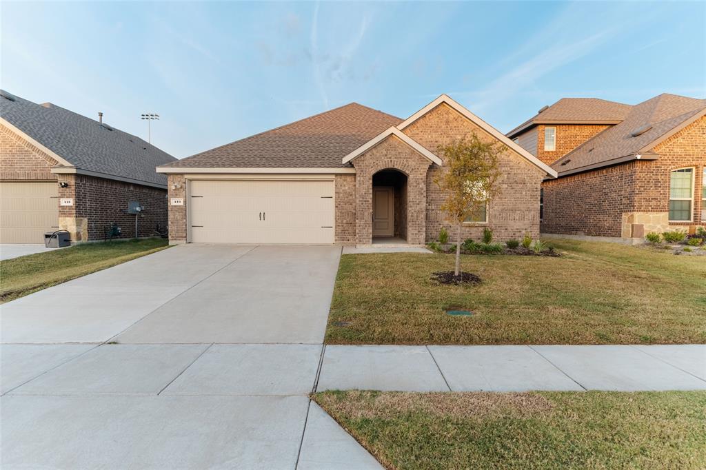 419 Revolution Road Fate, TX 75189 - Photo 1 of 19 View of front of house with brick siding, a front lawn, concrete driveway, roof with shingles, and an attached garage