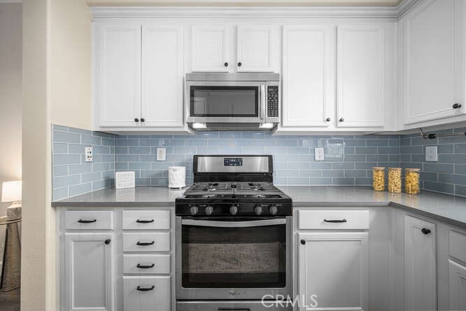 46 Hinterland Way Ladera Ranch, CA 92694 - Photo 14 of 46 a kitchen with granite countertop white cabinets and stainless steel appliances