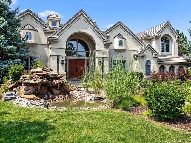 a view of a big house with a big yard and large trees