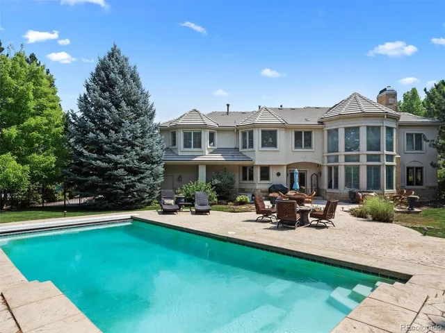 a front view of a house with sitting area and swimming pool