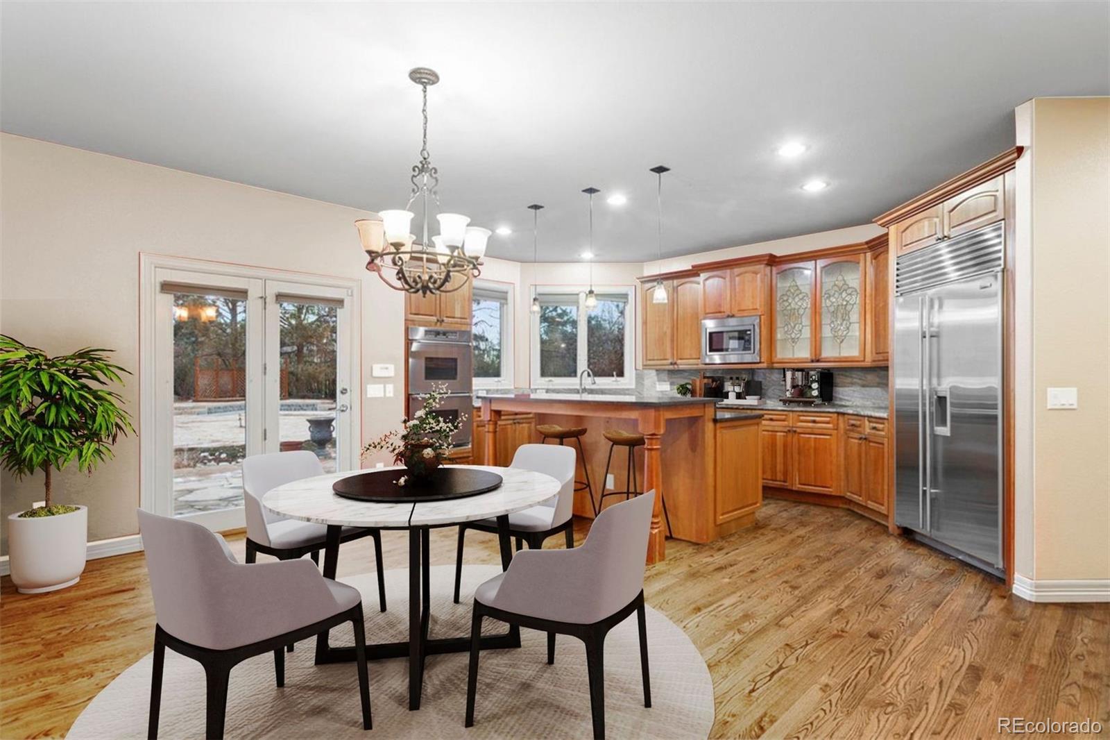 7125 Polo Ridge Drive Littleton, CO 80128 - Photo 10 of 25 a dining room with stainless steel appliances kitchen island granite countertop a kitchen island a dining table and chairs