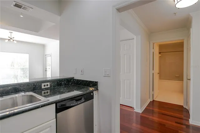 a view of a sink a mirror and wooden floor