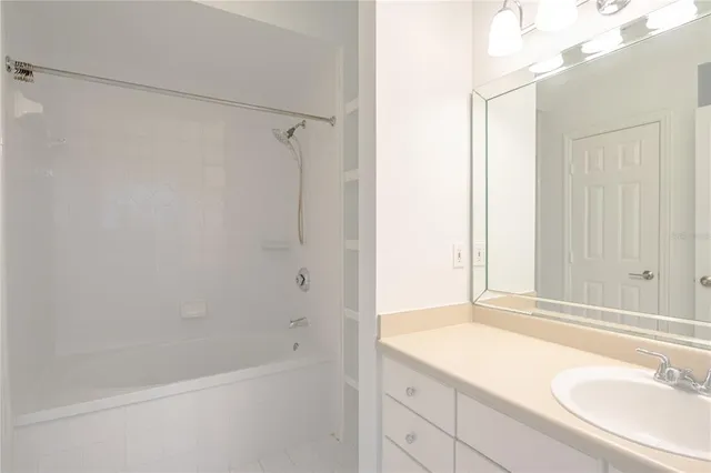 a bathroom with a granite countertop sink a mirror and a bathtub