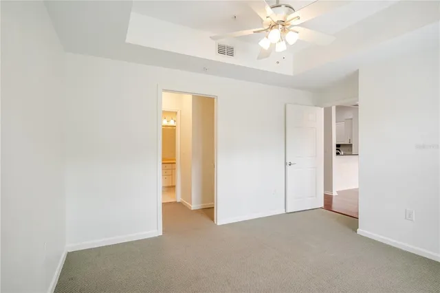 a view of an empty room and chandelier fan