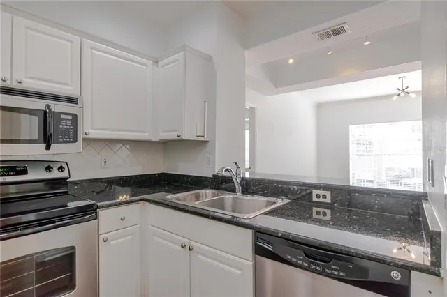 a kitchen with stainless steel appliances granite countertop a sink stove and microwave