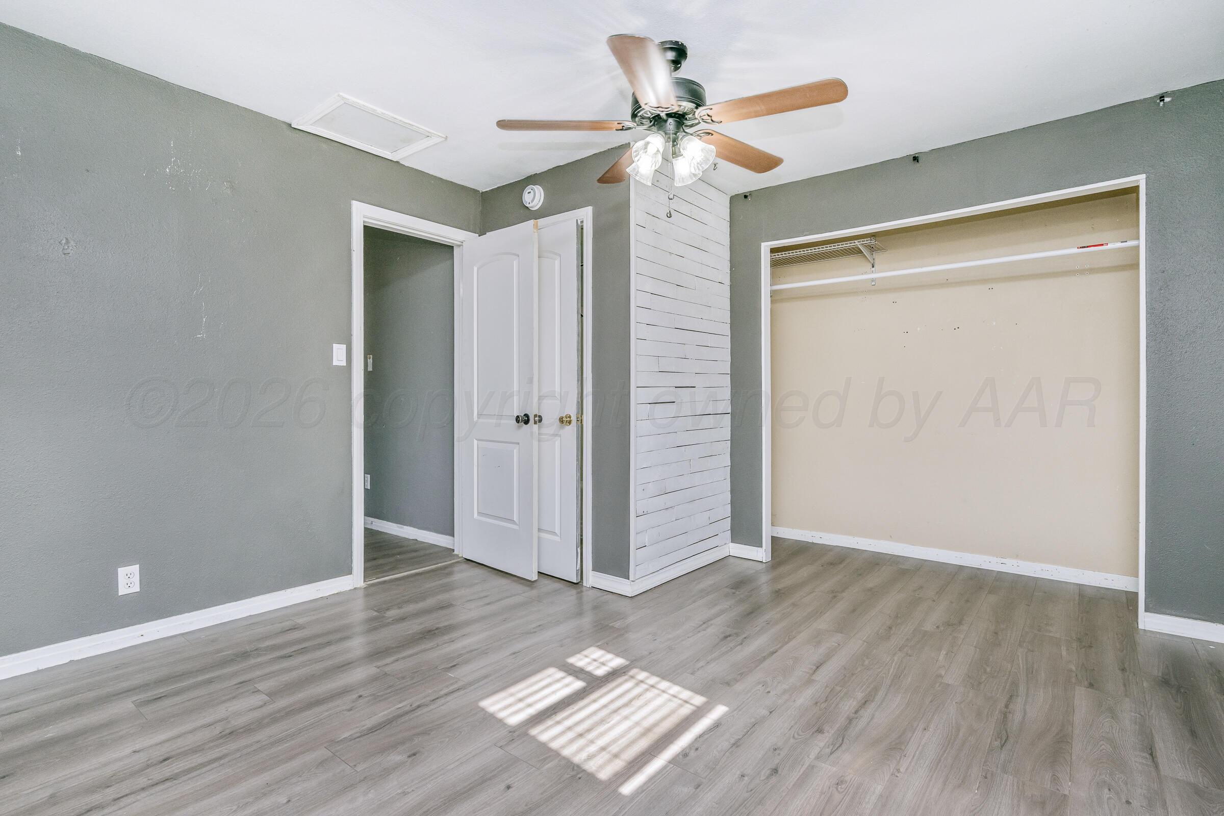 4429 Bowie Street Amarillo, TX 79110 - Photo 9 of 20 wooden floor in an empty room with a window