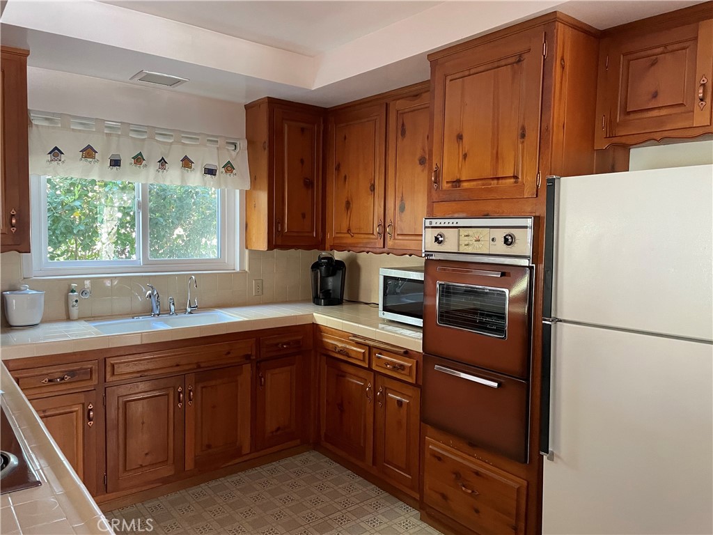 24935 Green Avenue Newhall, CA 91321 - Photo 3 of 11 a kitchen with a sink a stove and a refrigerator