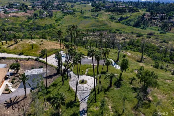 an aerial view of residential houses with outdoor space and trees