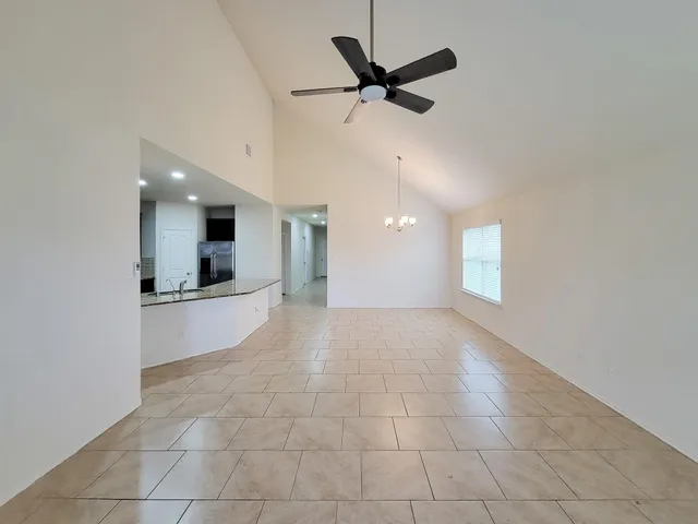 a view of an empty room and kitchen view