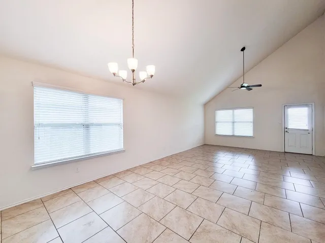 a view of a livingroom with a chandelier fan and windows