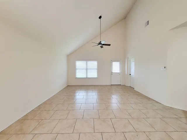 an empty room with windows and fan