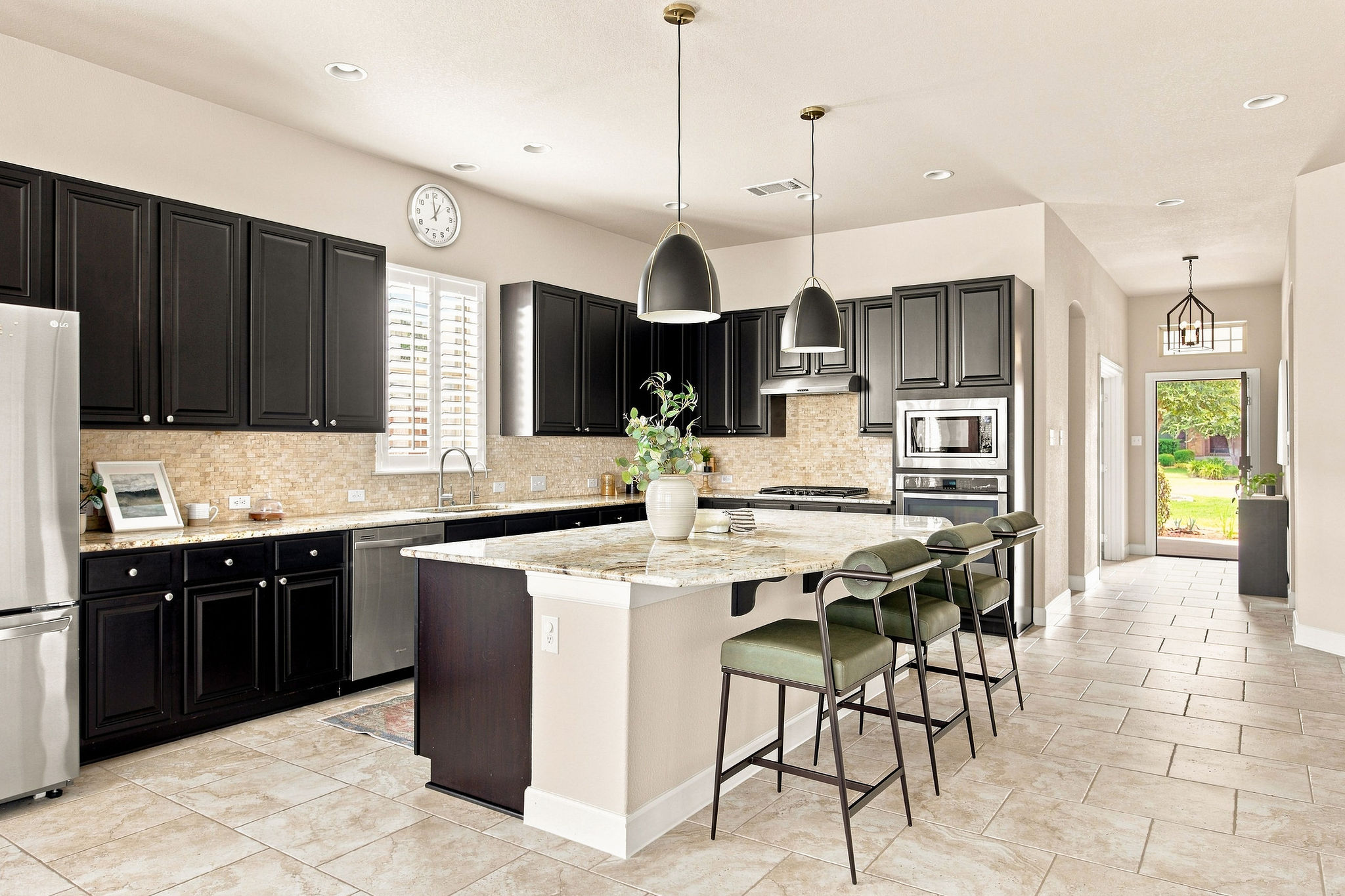 6100 Gunnison Turn Road Austin, TX 78738 - Photo 18 of 34 Granite countertops and dark cabinetry define this modern kitchen with stone tile flooring.