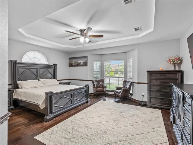a spacious bedroom with a bed and a dresser