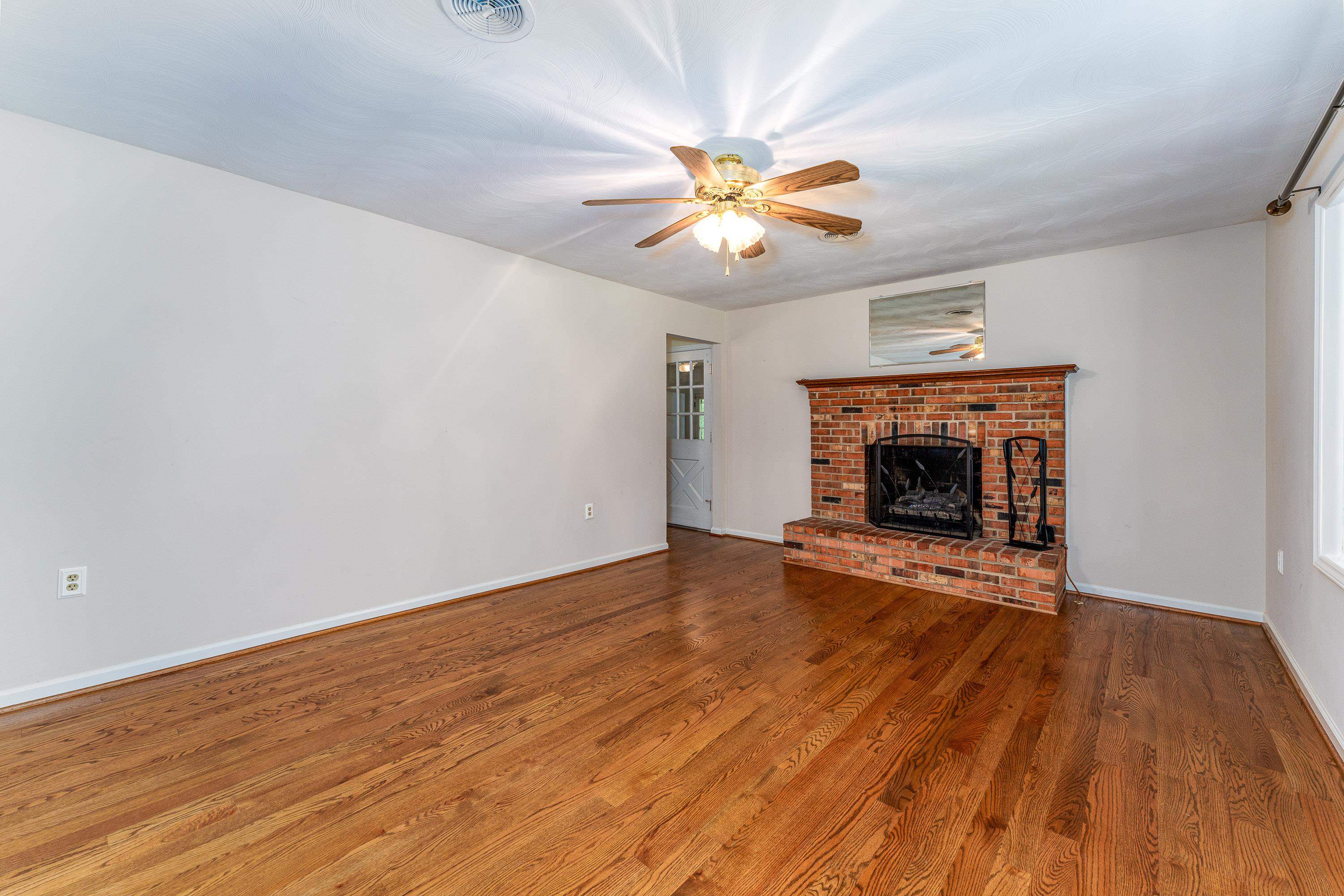 431 Springfield Estates Drive Rileyville, VA 22650 - Photo 11 of 44 a view of empty room with wooden floor and fireplace