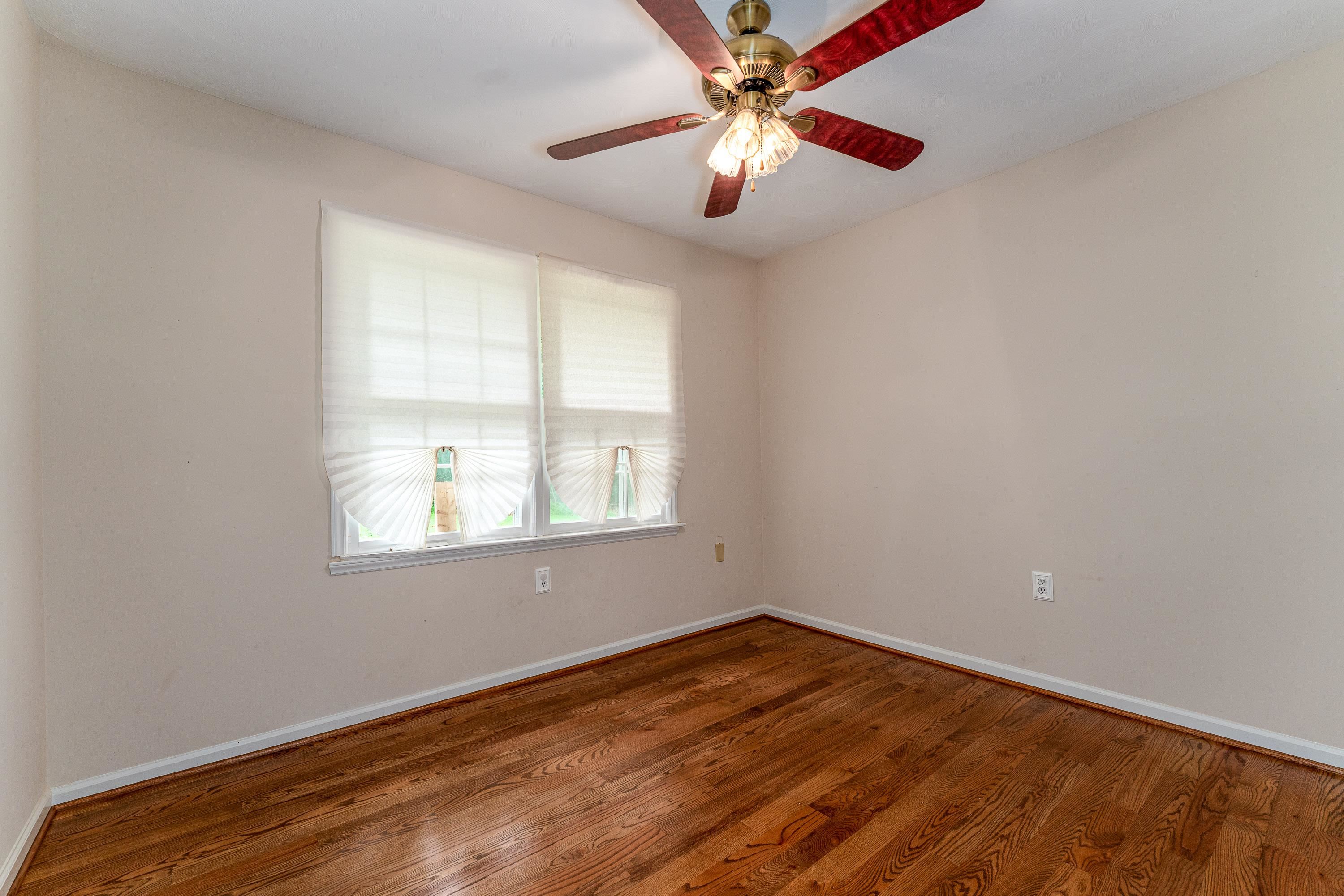 431 Springfield Estates Drive Rileyville, VA 22650 - Photo 19 of 44 an empty room with wooden floor fan and windows