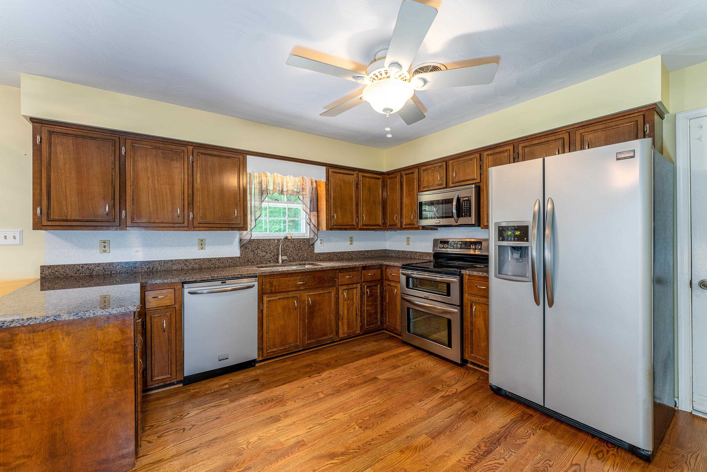 431 Springfield Estates Drive Rileyville, VA 22650 - Photo 6 of 44 a kitchen with stainless steel appliances granite countertop white cabinets a refrigerator a stove a sink and dishwasher with wooden floor
