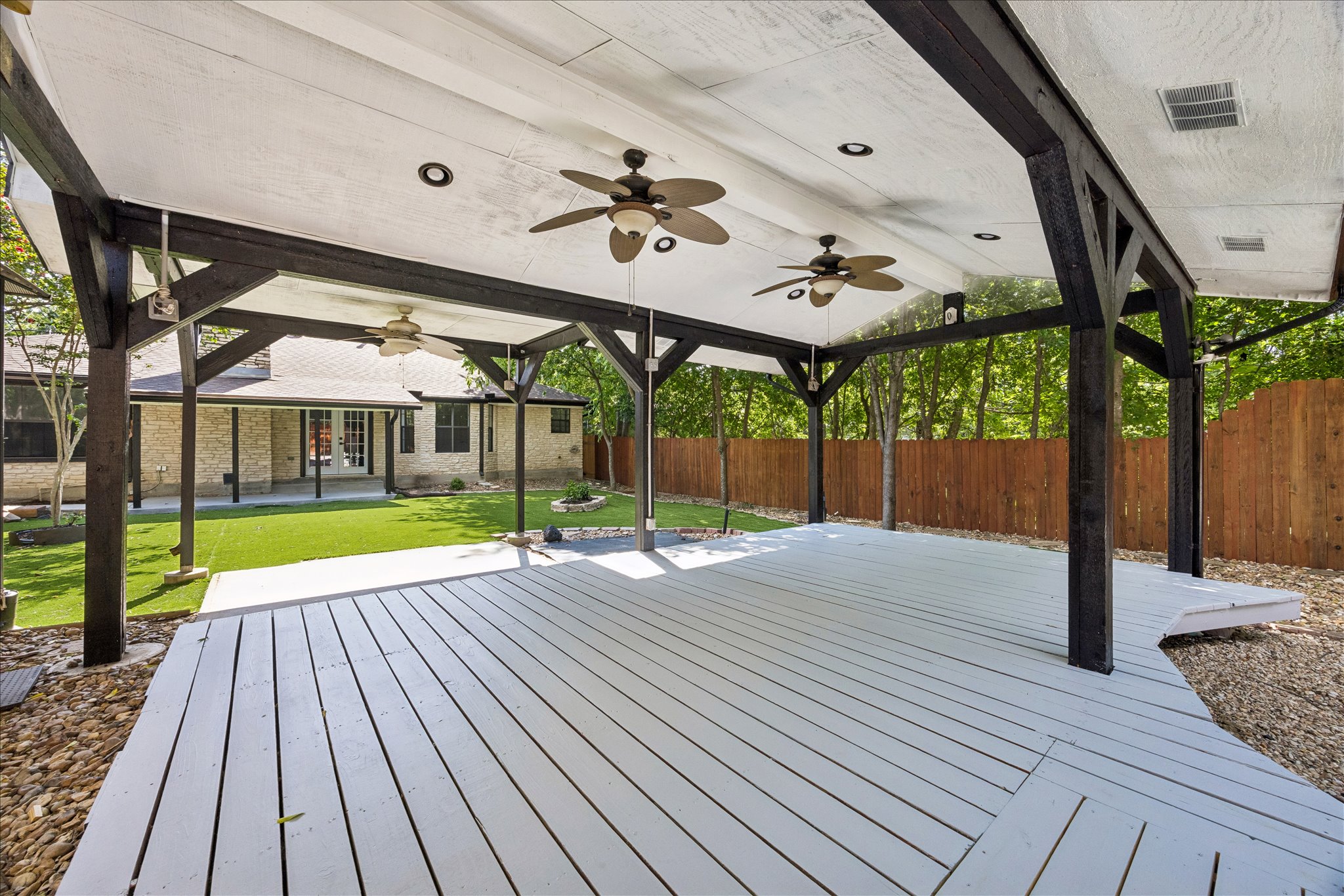 1706 Davis Street Taylor, TX 76574 - Photo 15 of 18 An inviting covered patio with ceiling fans offers a perfect outdoor retreat for relaxation and entertaining.