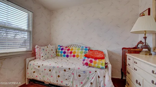 a bedroom with two beds and a lamp on dresser