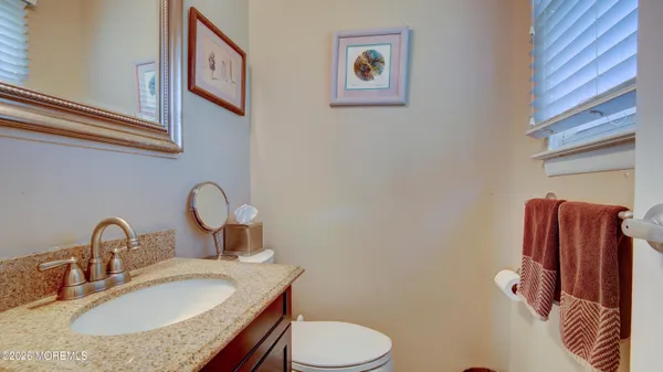 a bathroom with a granite countertop toilet sink and mirror