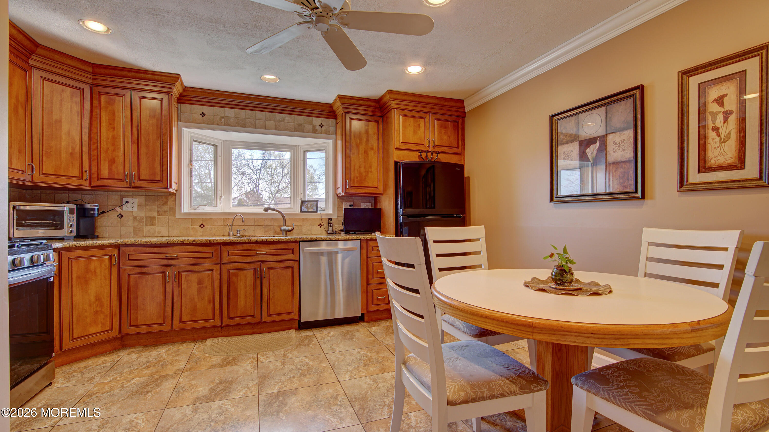12 Cavan Lane Hazlet, NJ 07730 - Photo 20 of 34 a kitchen with stainless steel appliances granite countertop a stove a sink dishwasher a dining table and chairs with wooden floor