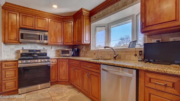 a kitchen with stainless steel appliances granite countertop a stove sink and cabinets