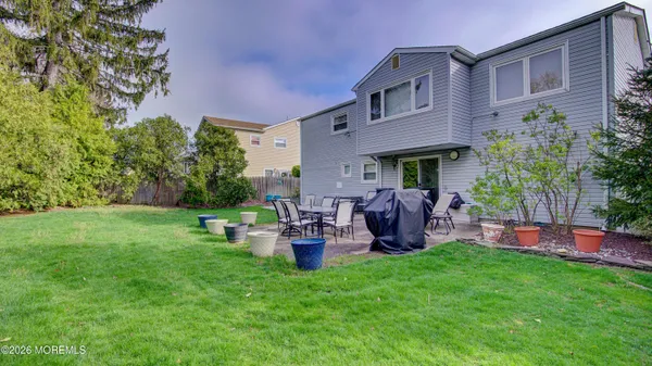 a view of a house with a backyard and chairs