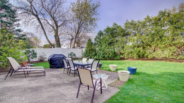 a view of a patio with table and chairs potted plants and a large tree