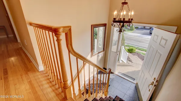 a view of staircase with railing and a chandelier