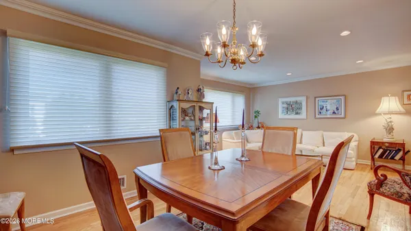 a view of a dining room with furniture a chandelier and wooden floor