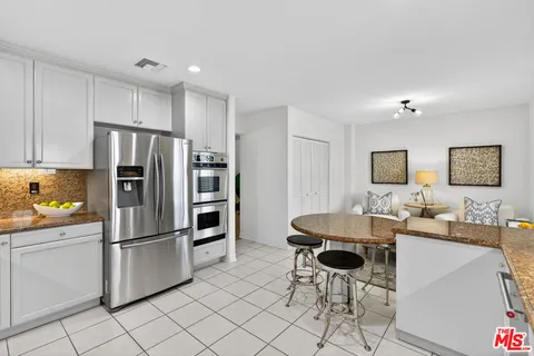 a kitchen with stainless steel appliances a refrigerator and a stove top oven