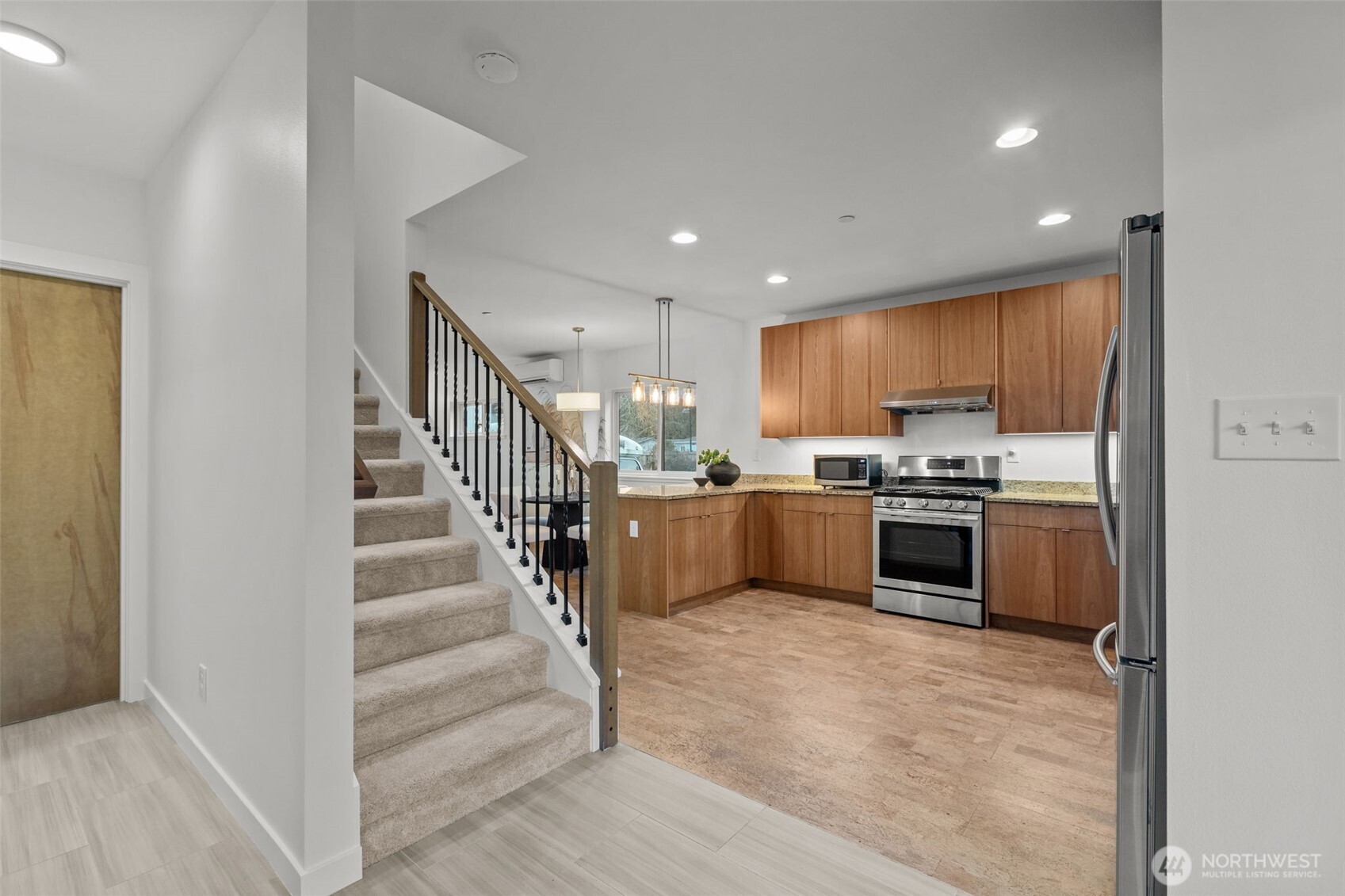 1402 194th Street Southeast, Unit 1 Bothell, WA 98012 - Photo 2 of 31 a open kitchen with kitchen island a stove a refrigerator and a sink