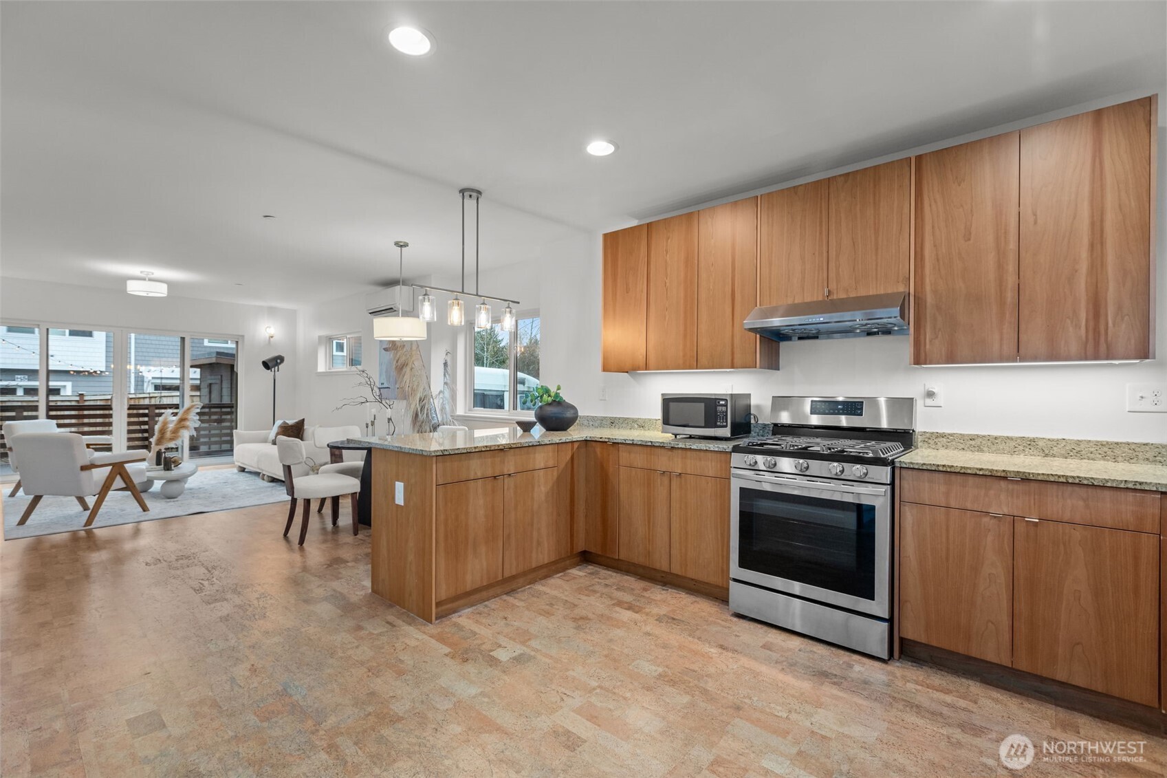 1402 194th Street Southeast, Unit 1 Bothell, WA 98012 - Photo 3 of 31 a kitchen with stainless steel appliances granite countertop a stove top oven a sink dishwasher a dining table and chairs with wooden floors