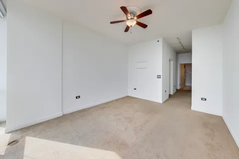 an empty room with a ceiling fan and closet area