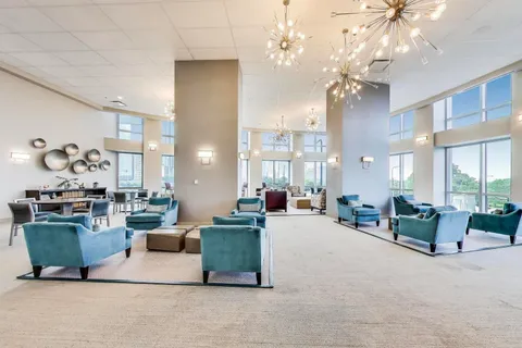 a living room with furniture a chandelier and a dining room