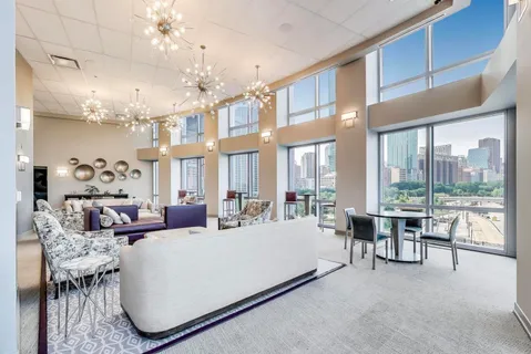 a living room with furniture or chandelier and a large window