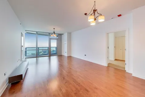 a view of a kitchen with wooden floor and a window