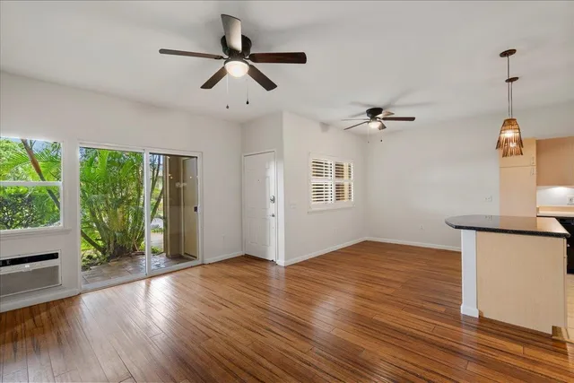a view of empty room with wooden floor and fan