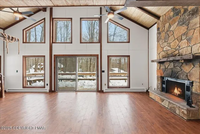 a view of an empty room with wooden floor and a fireplace