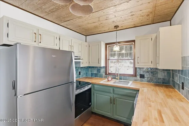 a kitchen with stainless steel appliances granite countertop a refrigerator a sink a stove a microwave and island