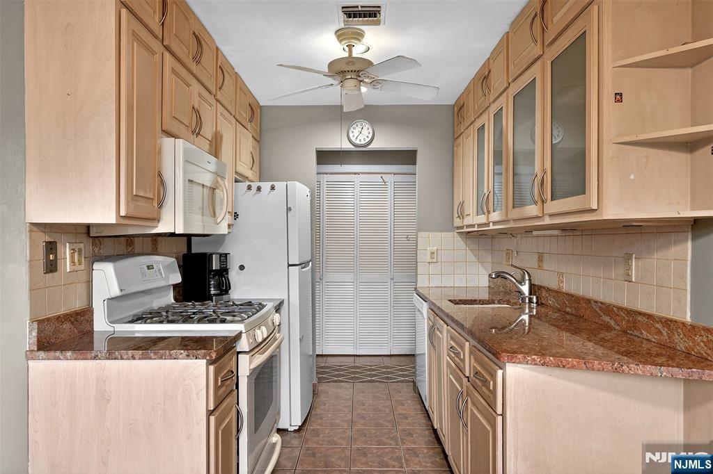 333 Liberty Street, Unit 4 Little Ferry, NJ 07643 - Photo 9 of 29 a kitchen with stainless steel appliances granite countertop a sink stove and refrigerator