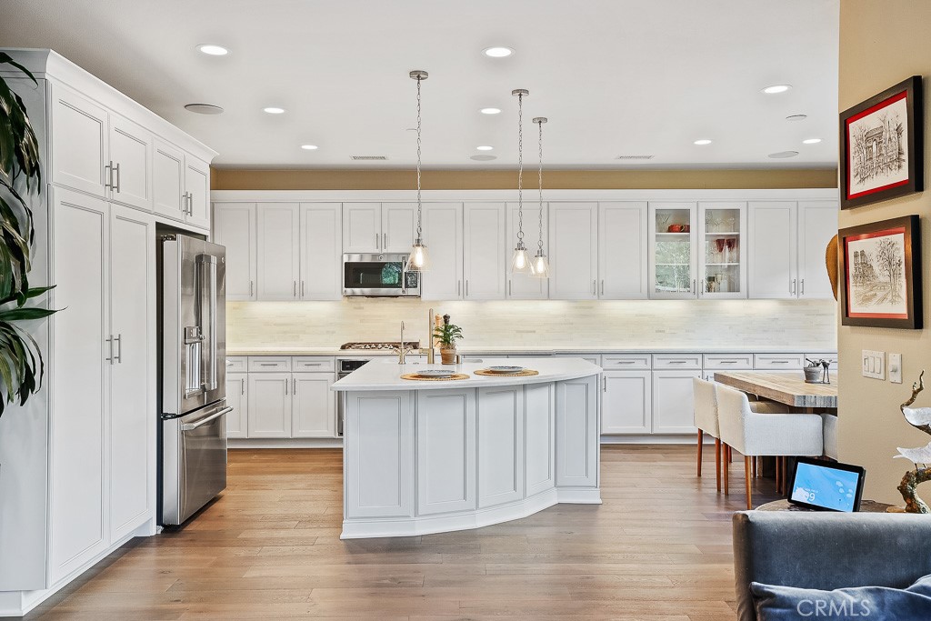 89 Lavender Lake Forest, CA 92630 - Photo 13 of 45 a kitchen with stainless steel appliances granite countertop a refrigerator a sink dishwasher a stove and white cabinets with wooden floor