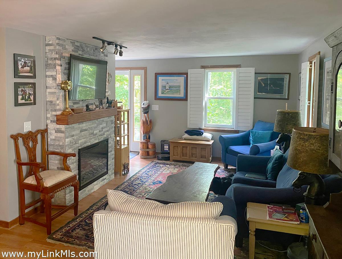 8 Old Purchase Road Edgartown, MA 02539 - Photo 7 of 26 a living room with furniture a large window and a fireplace