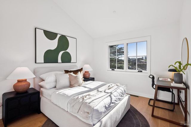a bedroom with a bed and a chair with the potted plant