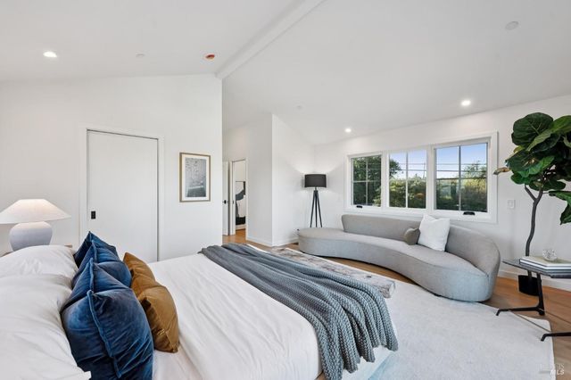 a bedroom with a bed and a large window