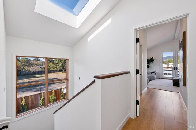 a view of a hallway with wooden floor and windows