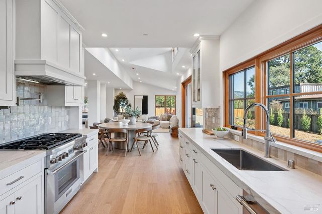 a large kitchen with a large window and stainless steel appliances